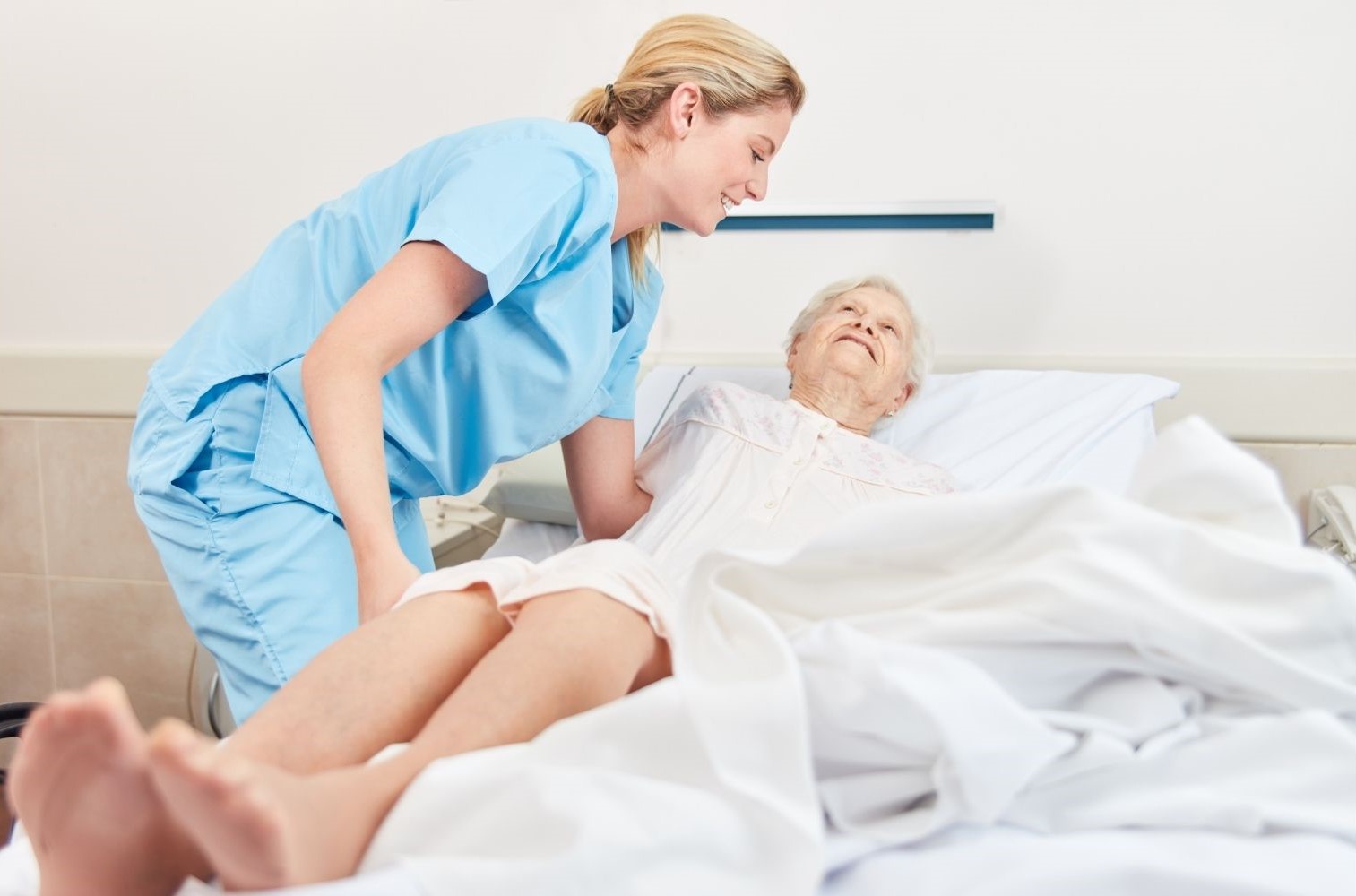 Umlagerung einer bettl&auml;gerigen Patientin durch eine Pflegekraft