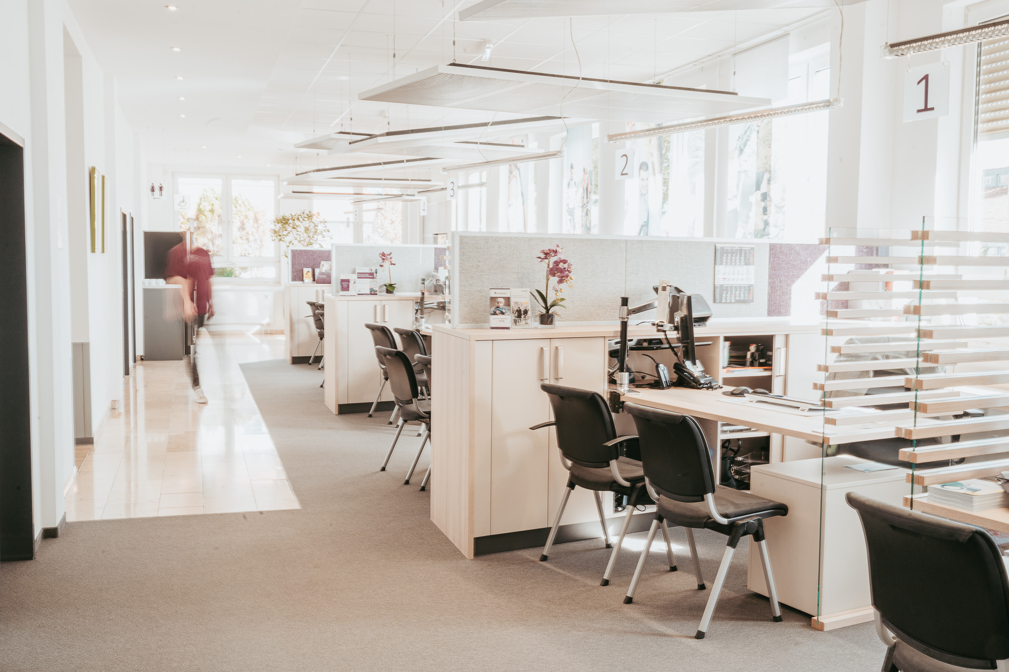 Mitarbeiter l&auml;uft durch Reha-Beratungsecke.