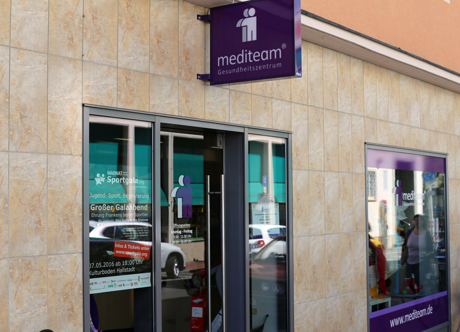 Eingang zum mediteam Gesundheitszentrum in Bamberg-Heinrichstra&szlig;e mit Schaufenster und &Ouml;ffnungszeiten.